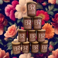 a group of jars stacked on top of each other with flowers in the background